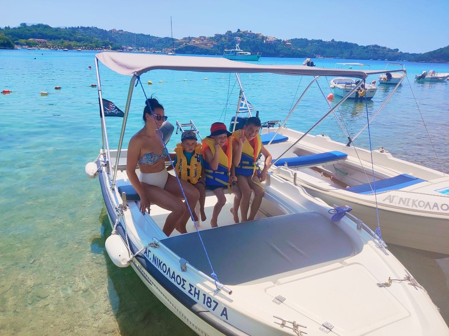 Visitors enjoying a small rental boat on the Ionian Sea in Sivota, Greece